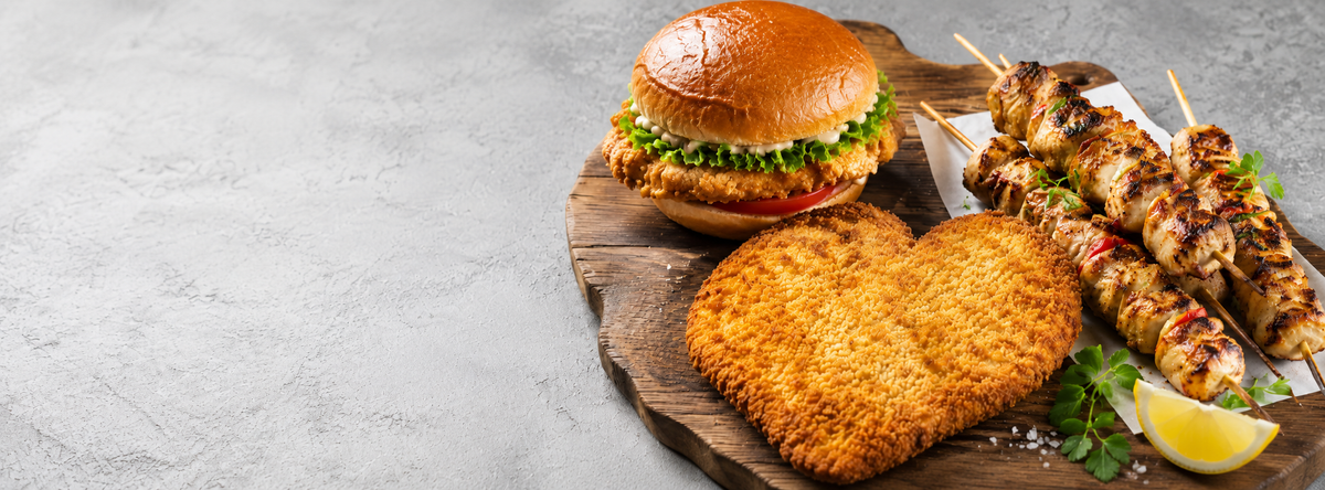 Chicken schnitzels and grilled chicken kebabs on a serving board
