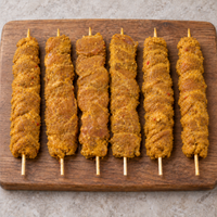 Six raw Large Satay Chicken Kebabs, 125g each, arranged on a wooden board