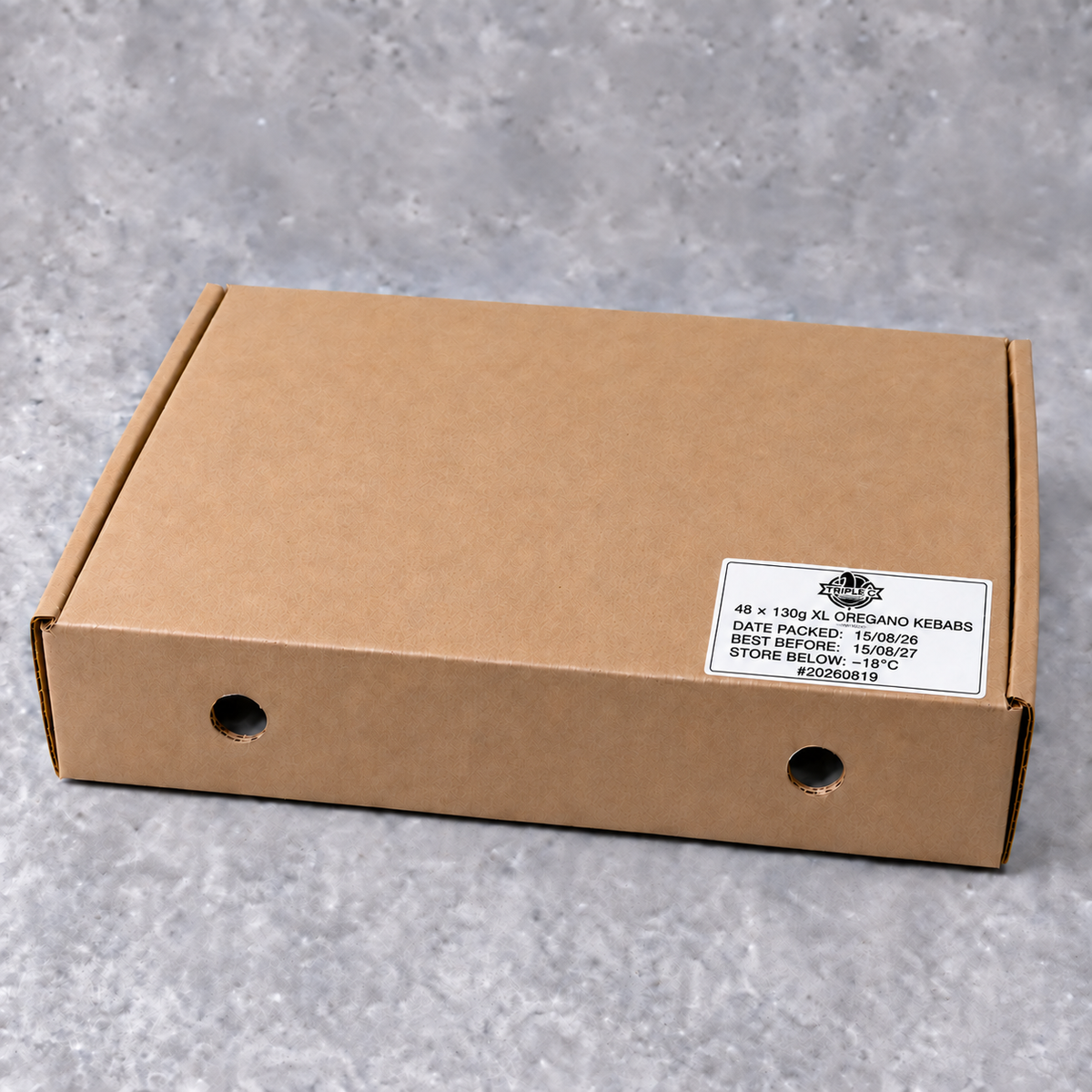 Brown kraft carton labelled 48 × 130g XL Oregano Chicken Kebabs, photographed on a neutral grey background.