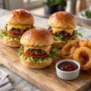 Three beef sliders with cheddar, lettuce and tomato in brioche buns, served with onion rings and barbecue sauce on an oak board.