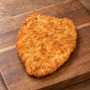 Par-cooked 200g+ chicken breast schnitzel coated in golden panko mixed crumb on a wooden serving board.